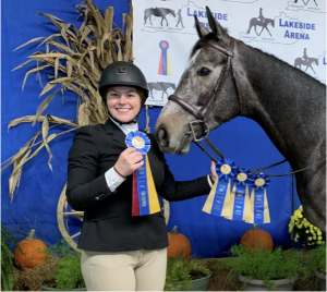 Christian and Junior posing with the ribbons they won at a horse show.
